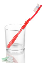 Toothbrush in glass and chewing gum isolated on white