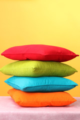 Fototapeta na wymiar Colorful pillows on yellow background