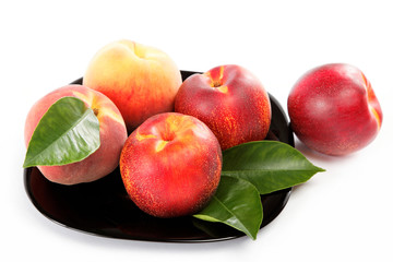 Fresh peaches and nectarines on a plate isolated on a white back