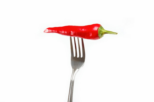 Red hot chili pepper pricked on the steel fork isolated © trotzolga