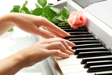 hands of woman playing synthesizer