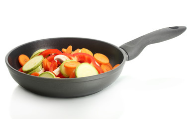 frying pan with vegetables on white