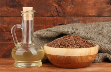 linseed oil with flax seeds on wooden background close-up