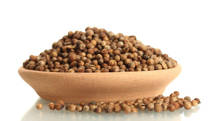 Heap coriander seeds in clay bowl isolated on white