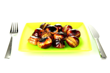 roasted chestnuts in the green plate with fork and knife
