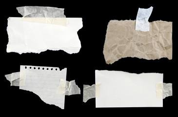 Four torn papers taped to black