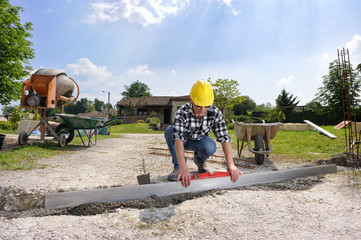 un maçon qui nivelle une fondation