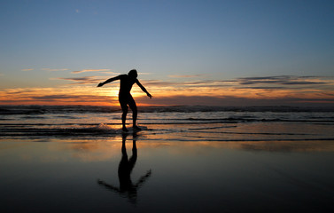 silhouette of skimboarder in sunset