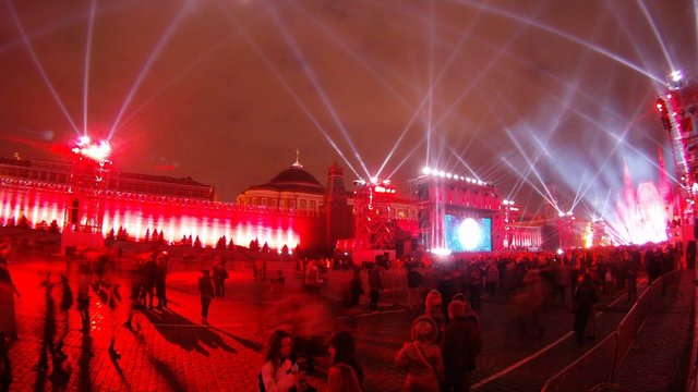 Many people stand and look laser show on Red Square