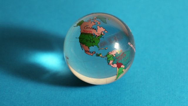 Red light flashes on transparent sphere with world map on it