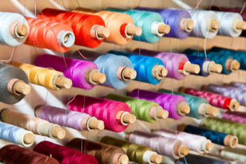 Bunte Garnrollen an einer Wandhalterung
