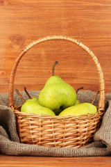 Ripe pears in sack on wooden background close-up