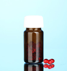 Jar of pills on blue background close-up