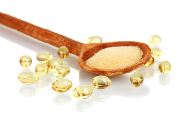 Gelatin in a wooden spoon on white background close-up