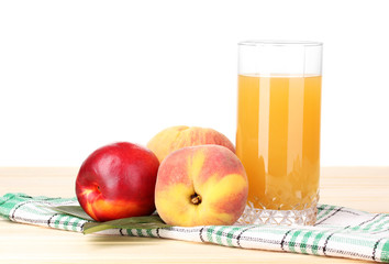 Ripe peaches and juice on wooden table on white background