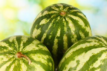 Ripe watermelon on green background close-up