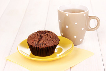 Fresh muffin with tea on wooden background