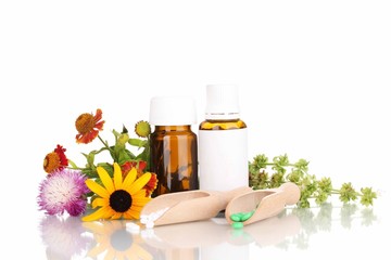 medicine bottles with tablets and flowers isolated on white
