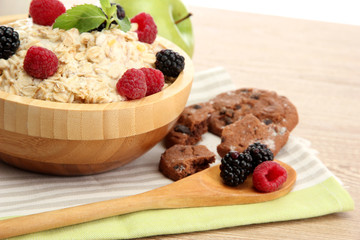 tasty oatmeal with berries, on wooden table