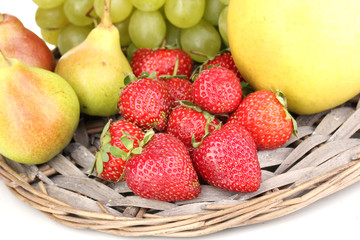 ripe sweet fruits and berries on wicker mat close-up