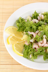 Delicious marinated shrimp in plate on bamboo mat