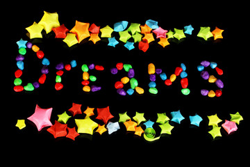 The word Dreams with colorful paper stars with dreams isolated