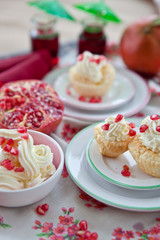 Little cakes with cream and pomegranate