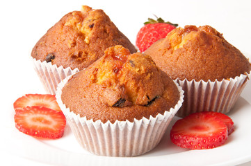 Strawberry muffin on a white plate with a fresh strawberry 