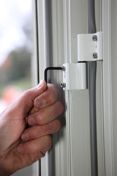 Man Tightening Window Hinge