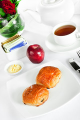 continental breakfast of croissant pastry and tea