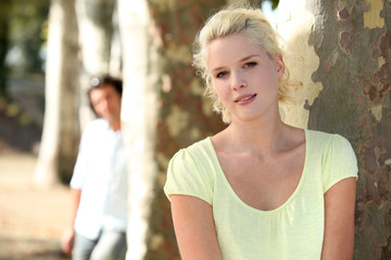 Fototapeta premium Couple standing in a park by trees