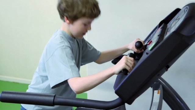 boy walks on treadmill and looks to panel