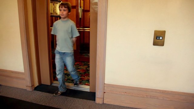 Automatic doors opens and little boy comes out from elevator