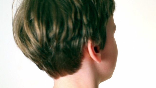 Little boy looks and turn around, only head visible isolated