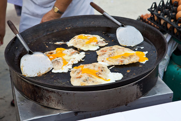 Oysters fried in egg batter being cooked in a pan