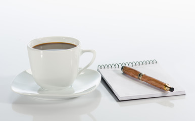 Cup of coffee, pen and notebook