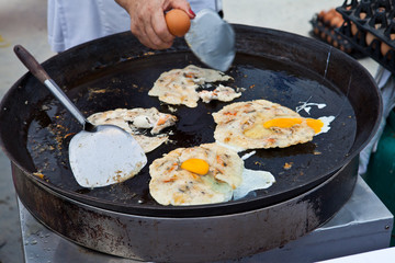 Oysters fried in egg batter being cooked in a pan