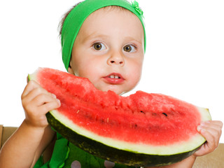 little boy eating a watermelon at a table