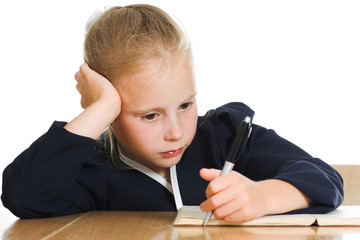 Schoolgirl writes at a table