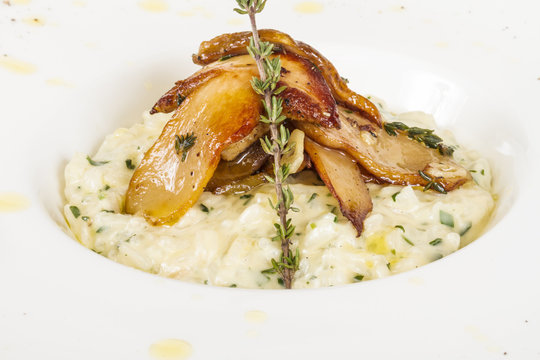 photo of delicious risotto dish with herbs and mushrooms on whit