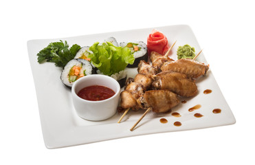 Buffalo chicken wings on plate with sushi