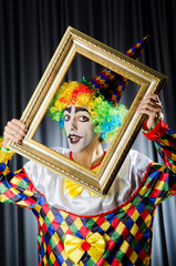 Clown with picture frames in studio
