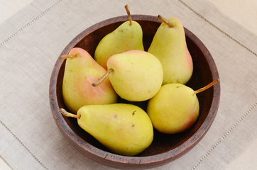 Yellow pears in old wooden bowl
