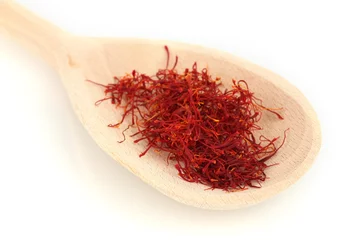 Foto op Canvas stigmas of saffron in wooden spoon on white background close-up © Africa Studio