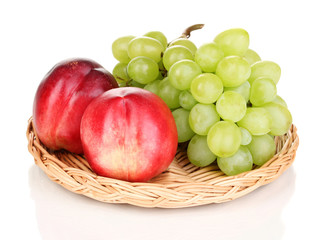 ripe sweet grapes and nectarines on wicker mat isolated on