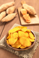 Crispy Peruvian sweet potato chips on wooden plate