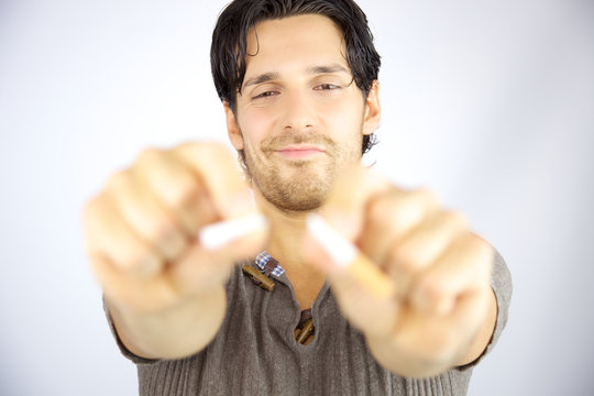 Man breaking cigarette in two pieces happy about stop smoking