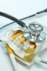 A doctors stethoscope lying on an open box of cigarettes