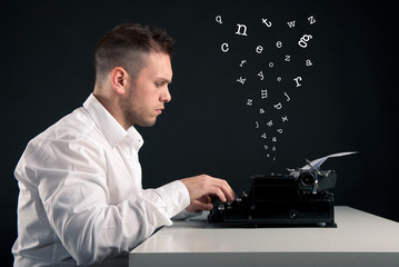 Young man writing with an old typewriter. Conceptual image