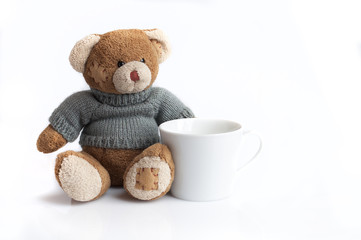 Teddy bear and a white cup isolated on white background
